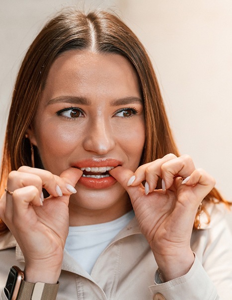 Patient putting on clear aligner in treatment room