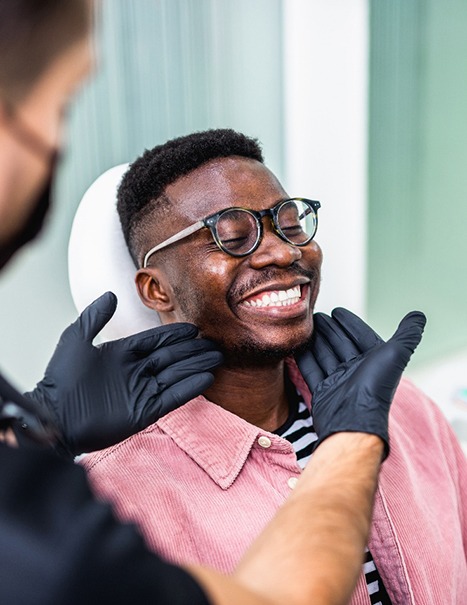 Dentist looking at patient's smile in treatment room
